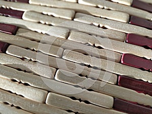 reed or wood mat. The rug is a mat under the hot. Knitted processed wood sticks with rounded edges. Close-up. Yellow  brown and