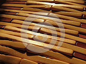 reed or wood mat. The rug is a mat under the hot. Knitted processed wood sticks with rounded edges. Close-up. Yellow  brown and