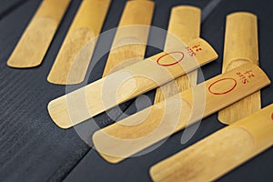 Reeds for a mouthpiece of a wooden instrument on gray wooden background
