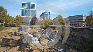 Reedy River Waterfalls in downtown of Greenville city in South Carolina. Falls Park riverwalk at Liberty bridge