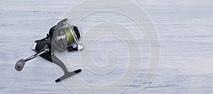 Reel with fishing line, for fishing, on a light gray background, with a place for the inscription