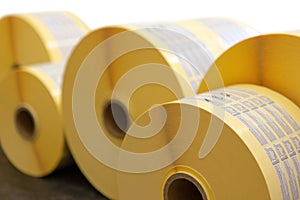 Reels of printed adhesive labels before slitting or cutting isolated on white background. Bunch of printed rolls