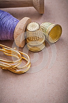 Reels of sewing threads thimbles safety pins on vintage backgrou