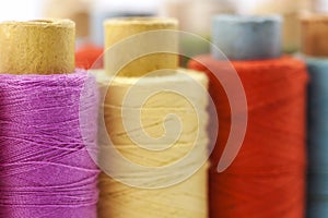 Reels or spools of multicolored sewing threads. Threads of all c