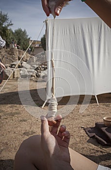 Reenactor using spindle with clay whorl