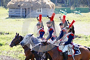 Reenactors-cuirassiers dressed as Napoleonic war soldiers ride horses