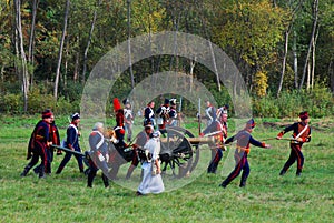 Reenactors dressed as Napoleonic war soldiers march on the battle field