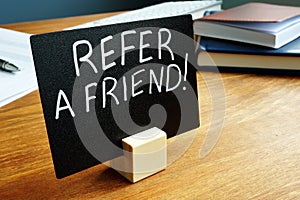 Refer a friend concept plate on the desk