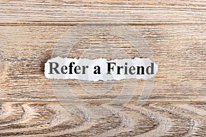 REFER A FRIEND text on paper. Word REFER A FRIEND on torn paper. Concept Image