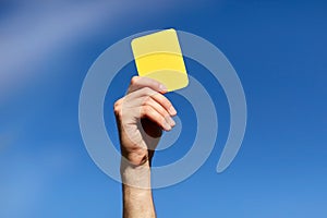 Referee on football field showing yellow card