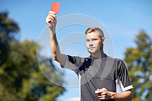 Referee on football field showing yellow card