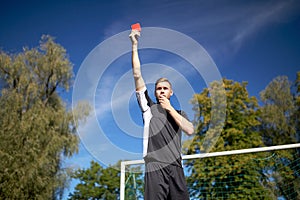 Referee on football field showing yellow card