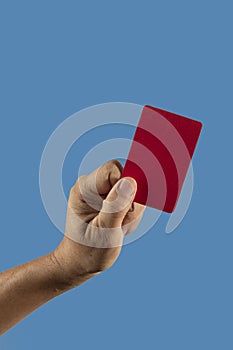 Referee hand holding red punishment card