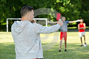 Referee showing red card in soccer stadium