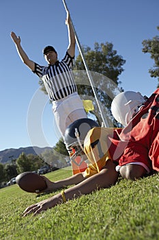 Referee signalling touchdown over football player