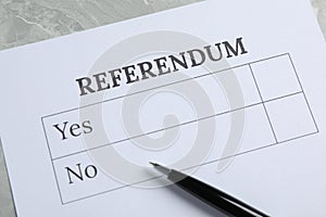 Referendum ballot with pen on grey table, closeup