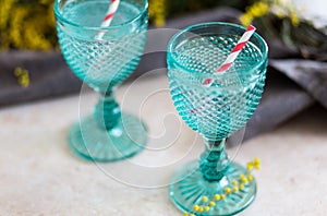 Refhesing drink in blue vintage goblets on the white background with srping flowers