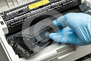 Refill and repair the printer cartridge. Gloved hand.