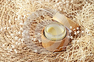 Refillable glass jar covered bamboo wood with medical salve or skin care herbal butter cream