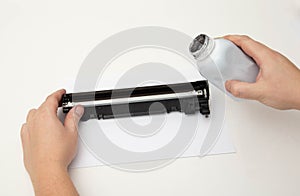 Refilling toner in a laser printer cartridge on a white background. Copy space for text