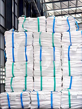 Refine sugar in white jumbo bag stack inside warehouse.