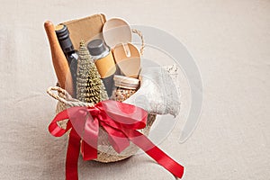 Refined Christmas gift basket for culinary enthusiats with bottle of oil, vinegar and kitchen utensils