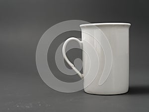 Refined sugar lump white and white cup on a gray background