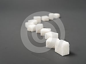 Refined sugar lump white and white cup on a gray background