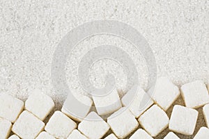 Refined white sugar powder and cubes. Wooden background