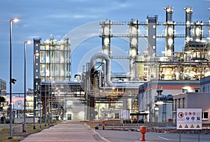 Refinery - chemical factory at night with buildings, pipelines and lighting - industrial plant