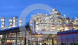 Refinery - chemical factory at night with buildings, pipelines and lighting - industrial plant