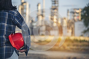 Refinery plant woman worker oil petrochemical industry hand holding red worker hard hat. Woman Emergency workers hands holding