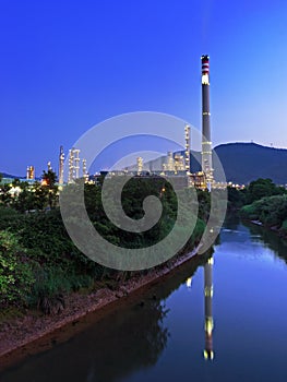 Refinery with smokestack near a river