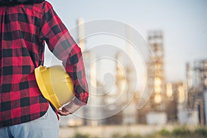 Refinery woman worker oil petro industry hand hold yellow worker helmet hard hat. Woman worker hands holding hardhat yellow work
