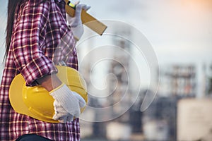 Refinery woman worker oil petro industry hand hold yellow worker helmet hard hat. Woman worker hands holding hardhat yellow work