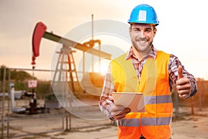 Refinery worker standing in front of the oil pump