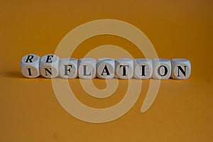 Reflation or inflation symbol. Turned wooden cubes and changed the concept word inflation to stagflation. Beautiful orange