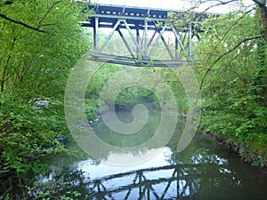 Reflecion of an iron arch bridge in a river