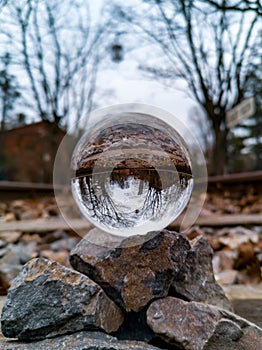 Reflected view by crystal glassy lensball on few small stones