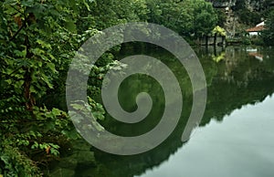 Silueta de verde montana es un refleja sobre el agua de un rio 