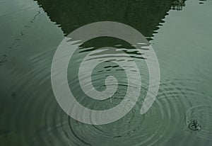 Silueta de verde montana es un refleja sobre el agua de un rio 