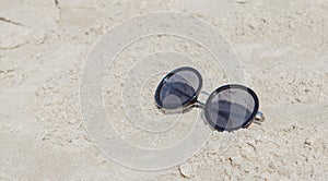 Reflecting sunglasses on the beach, glasses in the sand