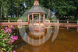 Reflection of the arbor in the water of the pond