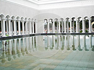 Reflection of arches in the water in the ablution area of the Sultan Omar Ali Saifuddin Mosque in Brunei