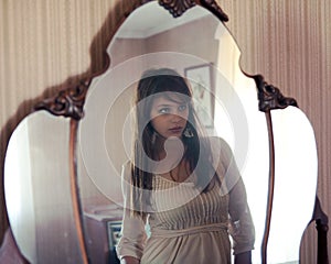 Reflection of Beautiful Young Woman in Mirror