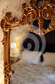 Reflection of a bed in a gold vintage mirror