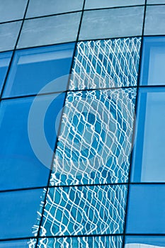 Reflection in blue glass wall of modern office building