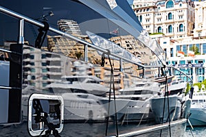 Reflection of a boat and city on a glossy surface of a huge yacht at sunny day, the chrome plated handrail, megayacht is photo