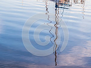 Reflection of a boat mast in the port of Olhao, Algarve region in south of Portugal, at sunset