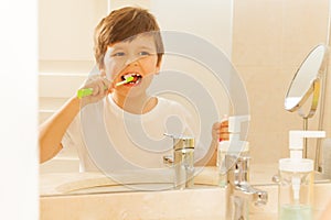 Reflection of boy in mirror during tooth brushing